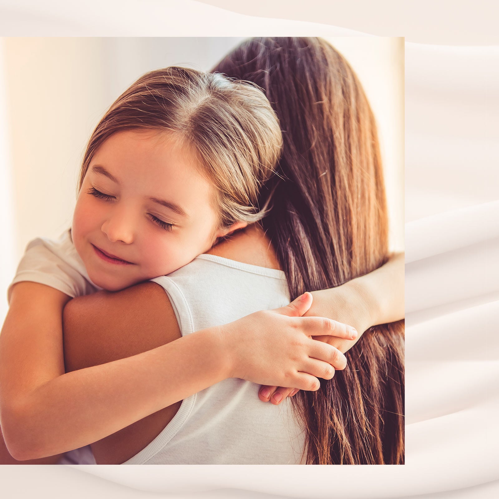 Pige med lukkede øjne giver en kærlig krammer til en voksen person med langt hår.