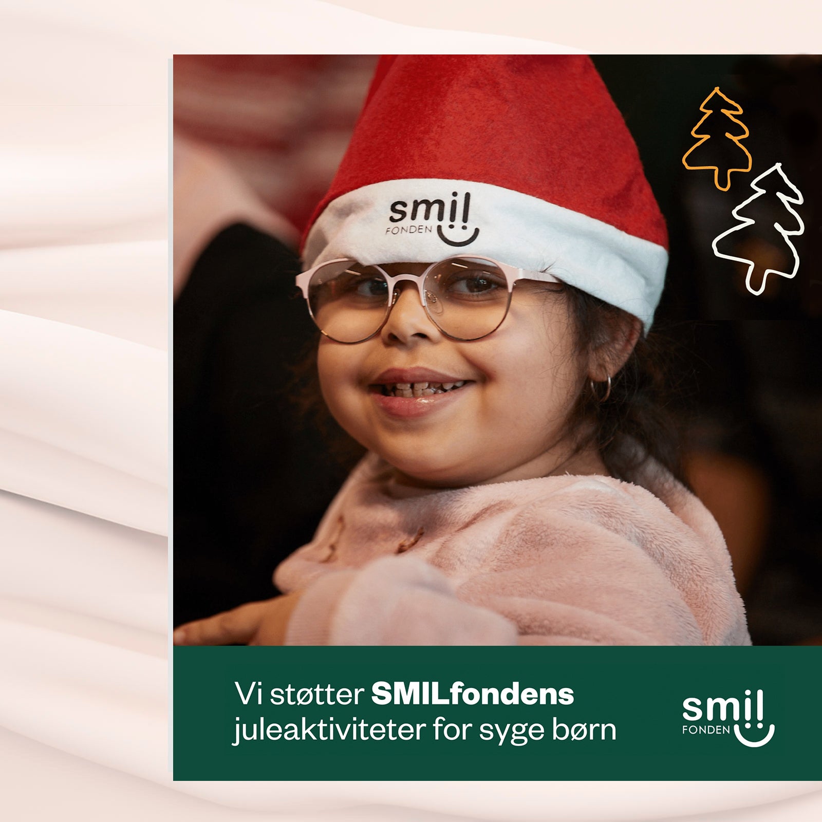 Smilende pige med briller og nissehue fra SMILfonden deltager i juleaktivitet.